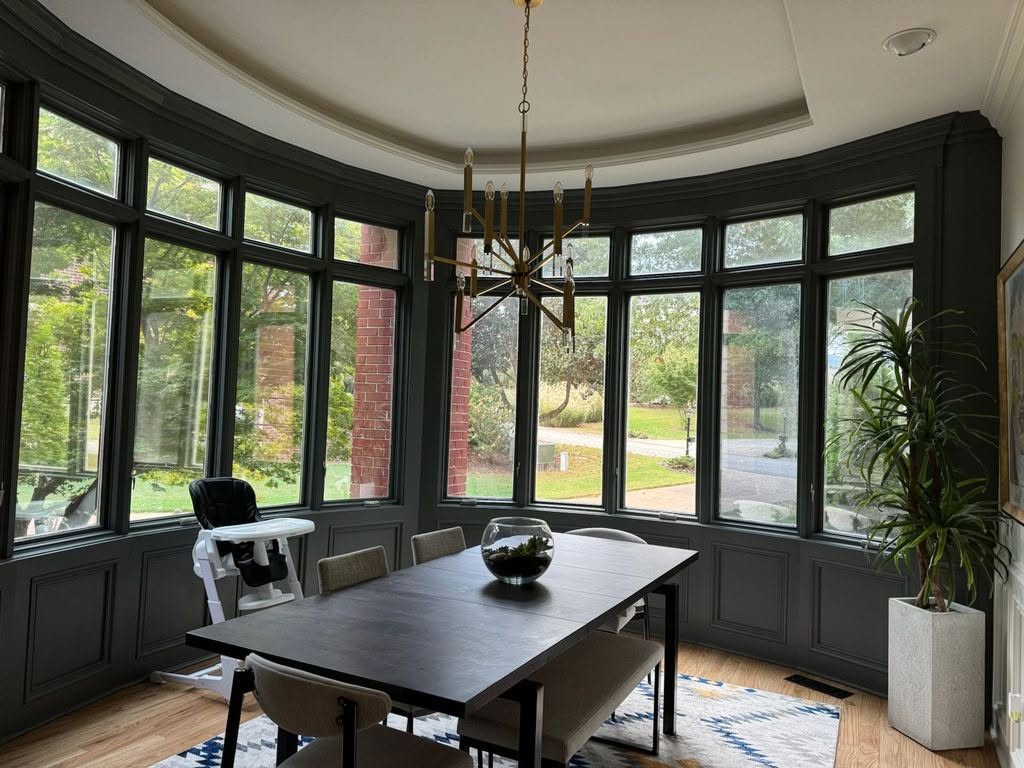Dining room with a curved bay of tall windows and residential window film by Solar Sentinel