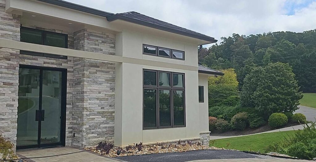 Modern stucco and stone home in Harrison, TN with window film on its large windows
