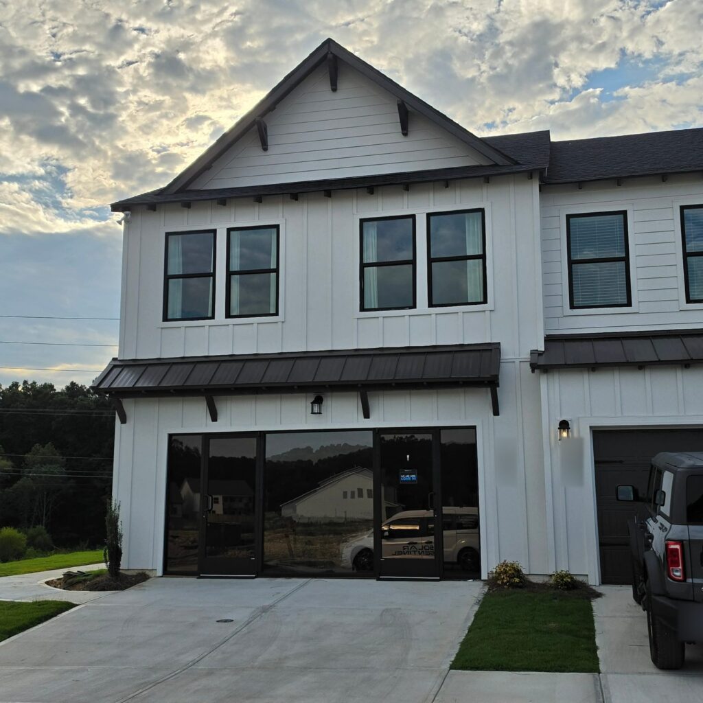 Modern white storefront in Hixson, TN with window film on its wide front windows and glass door